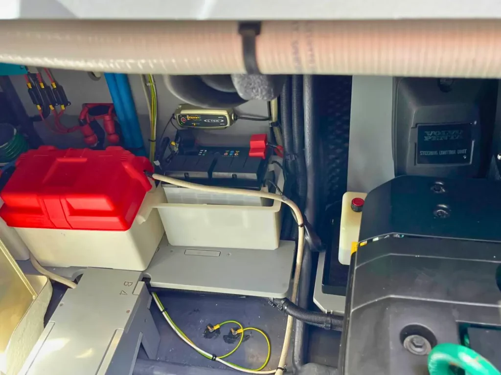 Maschinenraum einer Cranchi T36 Yacht mit einer roten Batteriekiste, verschiedenen Motorbauteilen und elektrischen Einrichtungen.