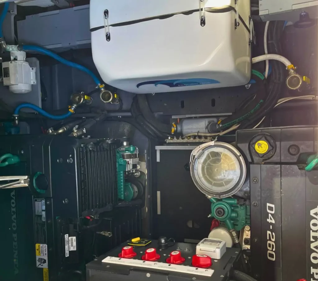 Nahaufnahme des Maschinenraums einer Cranchi T36 Yacht, die detaillierte mechanische Komponenten zeigt, einschließlich eines Volvo-Motors und verschiedener Anschlüsse.
