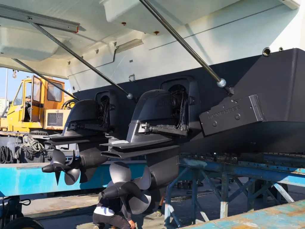 Antriebssystem einer Cranchi T36 Yacht, ausgestellt auf dem Trockendock, zeigt Zwillings-Außenbordmotoren und Propeller unter dem Heck des Schiffes.