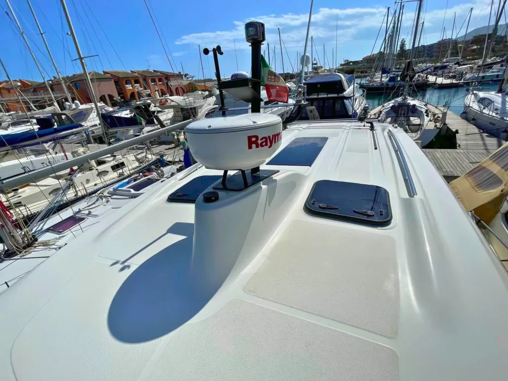 Ansicht des Oberdecks einer Cranchi T36 Yacht, die Radar-Ausrüstung und einen Sonnenbereich mit beige gepolsterten Sitzen zeigt.