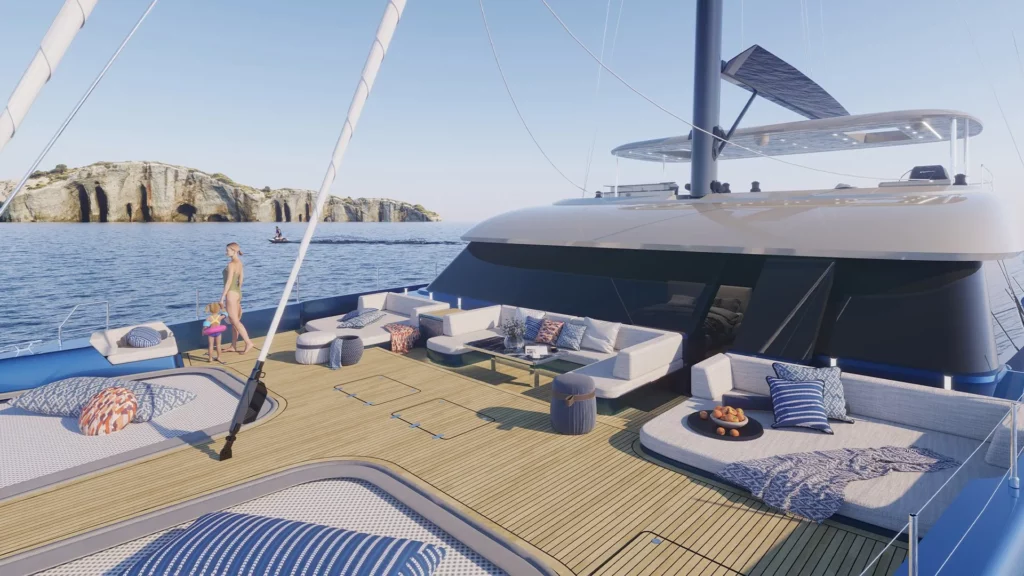 : Das weitläufige Vordeck der Sunreef 100, das mit Sonnenliegen, Sitzbereichen und modernen Accessoires ausgestattet ist, mit einem malerischen Meerblick und einem Felsen in der Ferne.