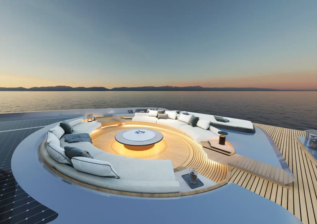 Nahaufnahme eines runden, in den Boden eingelassenen Sitzbereichs auf dem Deck einer Sunreef Yacht, der elegant mit Beleuchtung ausgestattet ist. Die umgebende Landschaft und der Sonnenuntergang verstärken die luxuriöse und entspannte Atmosphäre.