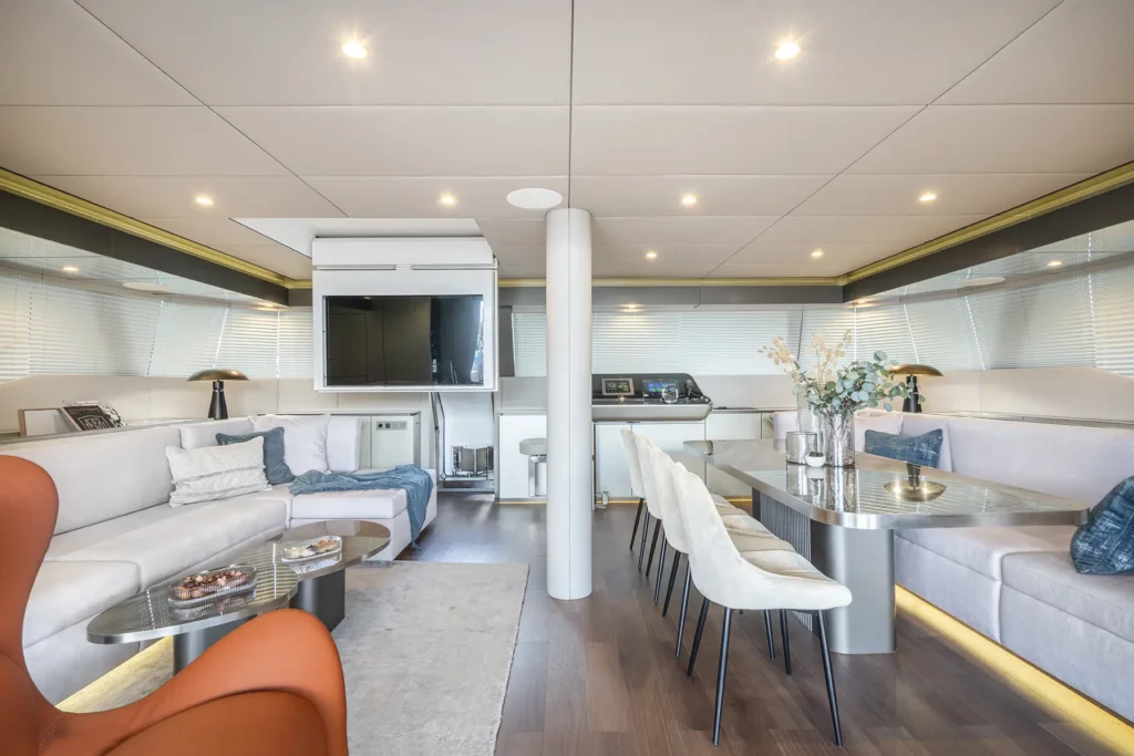 Stilvoller Wohnbereich auf der Sunreef 60, ausgestattet mit einem bequemen Sofa, Couchtisch und großen Fenstern mit Blick auf den Ozean.