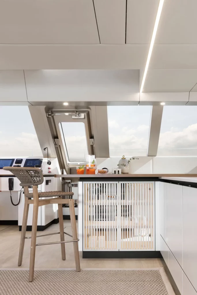 Ein Barbereich auf der Sunreef Yacht mit eleganter Theke und modernen Barhockern. Das offene Design verbindet den Innenraum nahtlos mit dem Außenbereich.