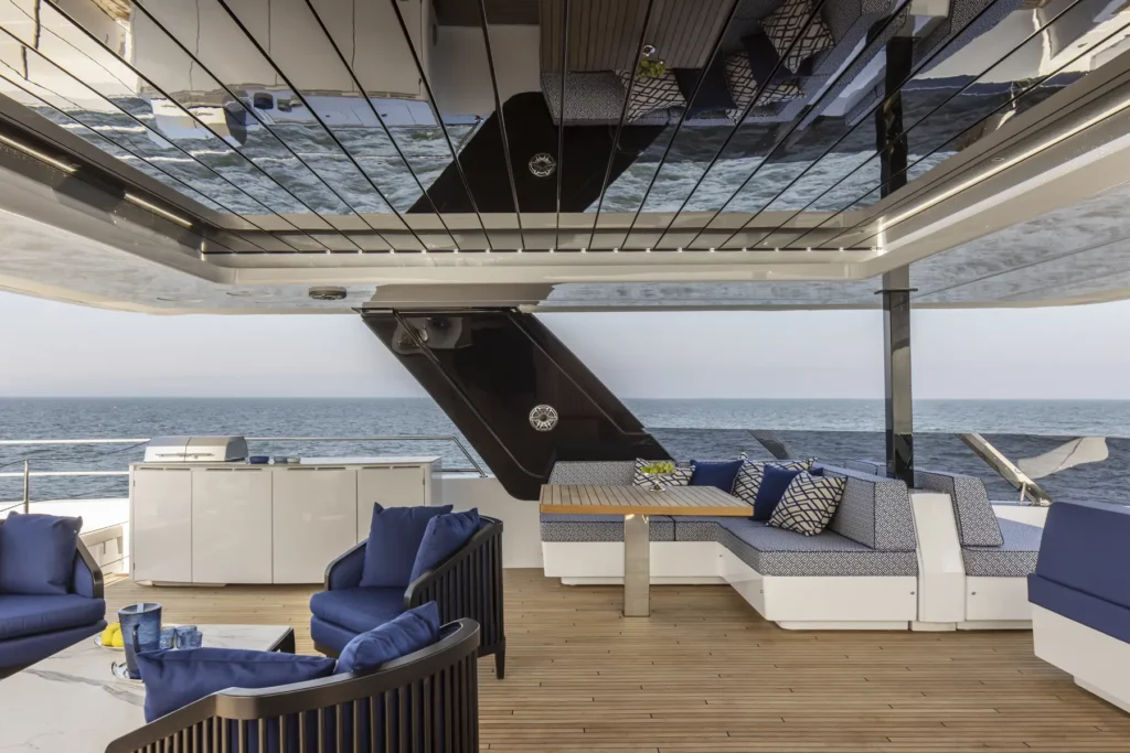 Blick auf die Flybridge der 80 Sunreef Power, die mit komfortablen Sitzbereichen und einem stilvollen Esstisch ausgestattet ist, ideal für entspannte Mahlzeiten im Freien.