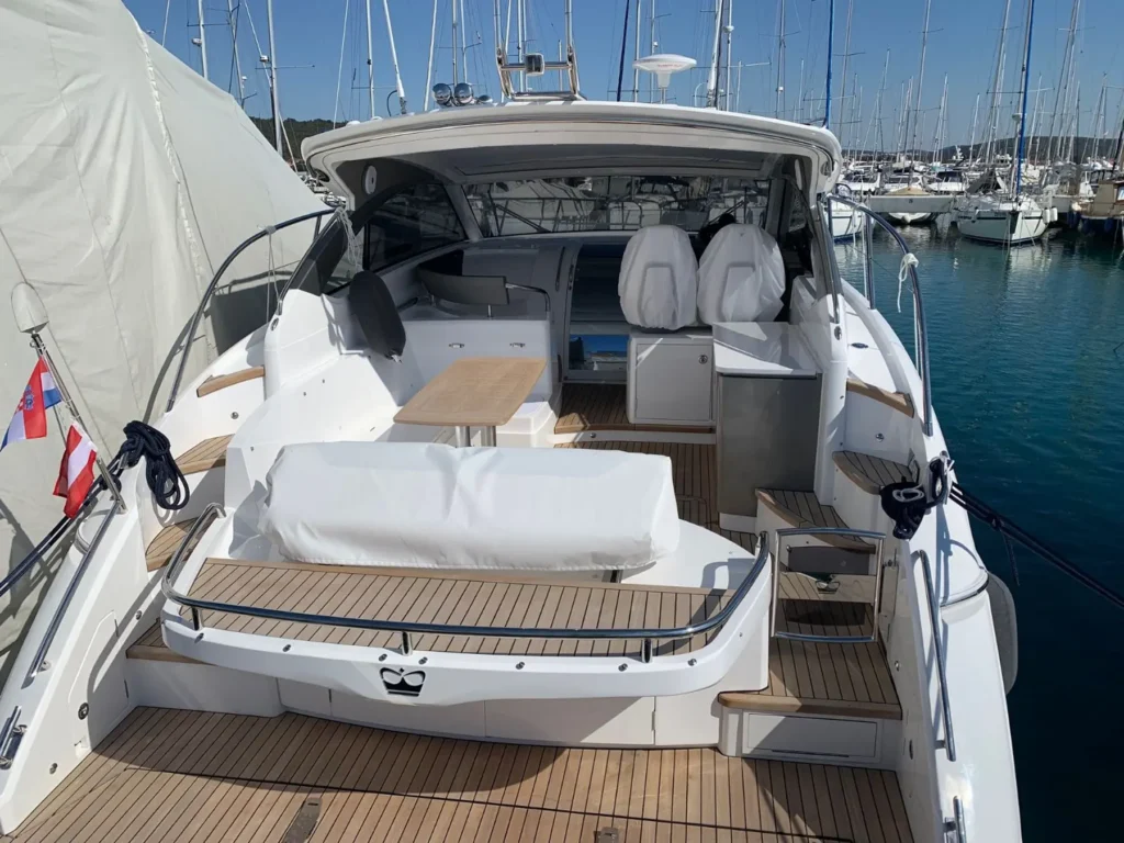 Das offene Heck der Princess V40 2022 mit Sitzgelegenheiten, Esstisch und geschmackvoll integriertem Cockpit-Design, ideal für gesellige Abende.